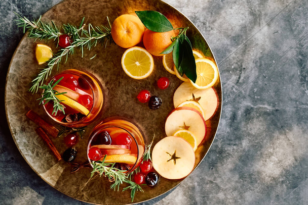 Mulled wine or christmas sangria with aromatic spices, apple, cherry and citrus fruits. Traditional Christmas festive warming spiced drink with orange, berry, cinnamon, cardamom and anise. - Photo, Image