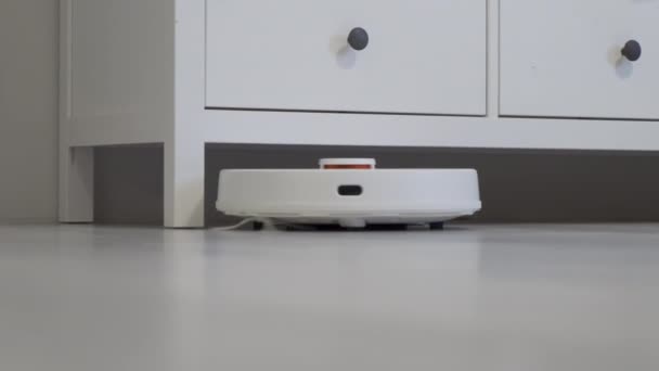 robot stofzuiger reinigt rond de tafel, slimme sensoren. Hoge kwaliteit 4k beeldmateriaal - Video