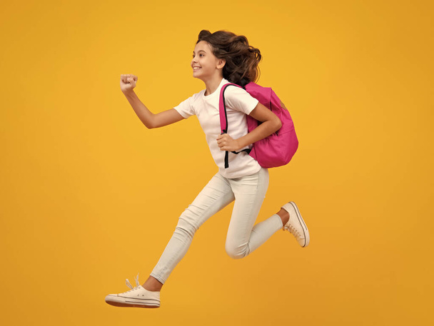 Schoolgirl with backpack. Teenager student, isolated background. Learning and knowledge. Go study. Crazy run and jump. Children education concept. Back to school - Photo, Image