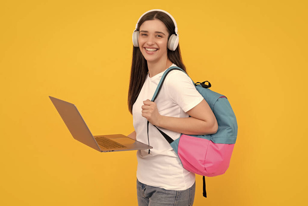 ευτυχισμένη κυρία στα ακουστικά χρησιμοποιώντας το σακίδιο μεταφοράς PC, επικοινωνία. - Φωτογραφία, εικόνα
