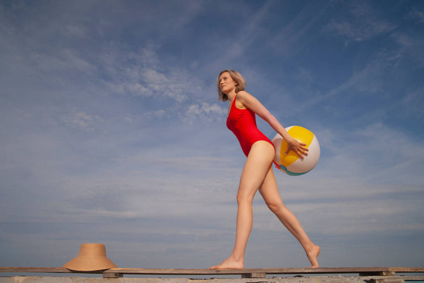 młoda szczupła kobieta w stroju kąpielowym z piłką plażową - Zdjęcie, obraz