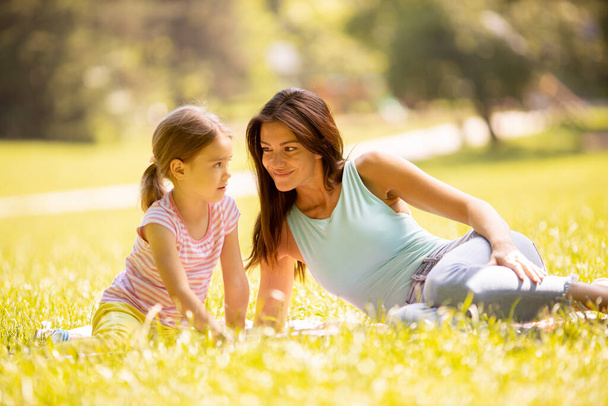Мама з милою маленькою донькою розважається в парку в сонячний день
 - Фото, зображення