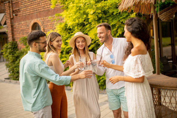 Group of happy young people cheering and having fun outdoors with drinks - Φωτογραφία, εικόνα