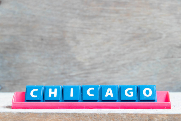 Tegel alfabet letter met woord chicago in rode kleur rek op houten achtergrond - Foto, afbeelding