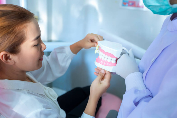 "The dentist is demonstrating how to brush teeth for the patients" - Photo, Image