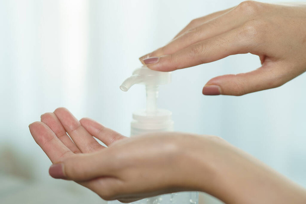 Mains féminines utilisant le distributeur de pompe de gel désinfectant pour les mains.  - Photo, image
