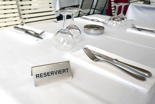 Un panneau avec l'inscription RÉSERVÉ sur une table dans un café ou un restaurant - Photo, image
