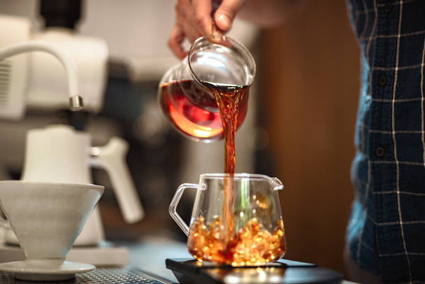 Barista faire un café Geisha, verser de l'eau chaude de la bouilloire sur une poudre de café moulue - Photo, image