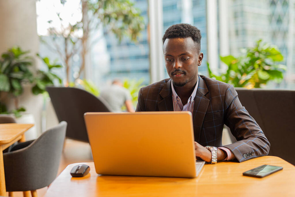 Empresário africano usando computador portátil no café - Foto, Imagem