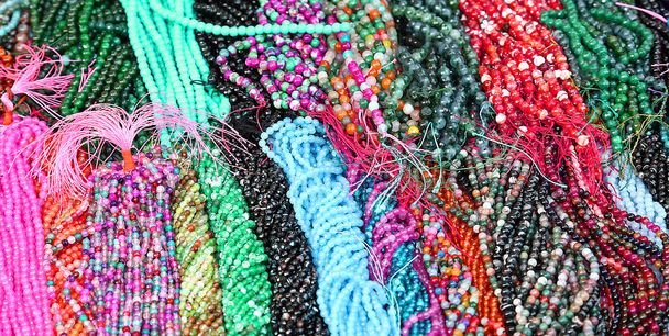 намисто з перлами багатьох кольорів на продаж на ринковій стійці
 - Фото, зображення