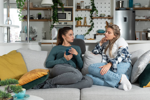 Young lesbian couple at home have a problem and argue due to jealousy caused by chatting and flirting via social media networks on smart phones, relationship difficulties problems and distrust. - Valokuva, kuva