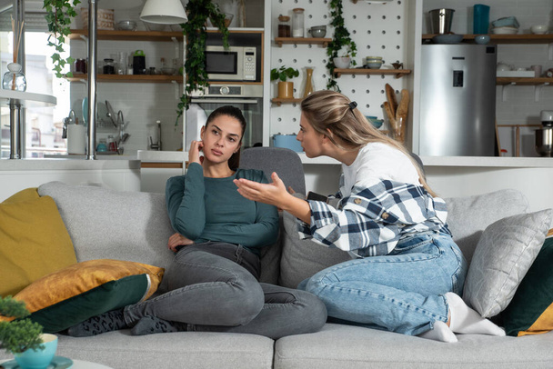 Young lesbian couple at home have a problem and argue due to jealousy caused by chatting and flirting via social media networks on smart phones, relationship difficulties problems and distrust. - Valokuva, kuva