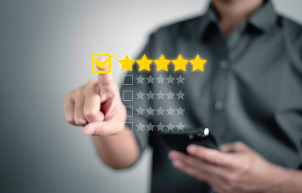 Customer service and Satisfaction concept, Businessmen touching the virtual screen and doing mark to five yellow stars to give satisfaction in service. rating very impressed. - Photo, Image