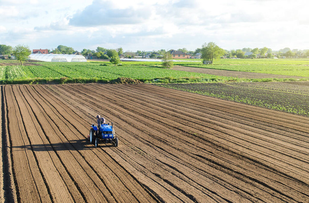 Farmář na traktoru zpracovává pole. Zemědělství a zemědělství. Příprava půdy na novou výsadbu plodin. Uvolnění povrchu, obdělávání půdy pro další výsadbu. Práce na zemi - Fotografie, Obrázek