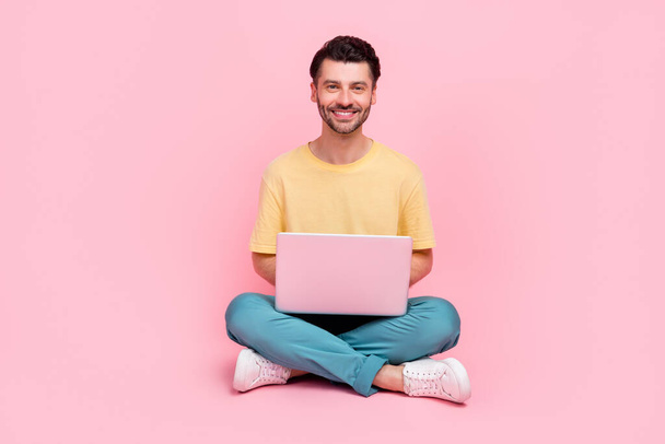 Zdjęcie inteligentny człowiek nosić modne ubrania korzystać netbook samsung lenovo cieszyć się jak jakości gadżet izolowane na różowym tle kolor. - Zdjęcie, obraz