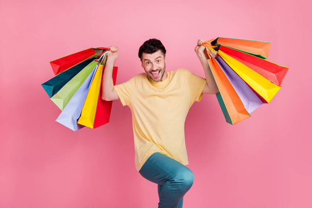 Photo of positive good mood man dressed yellow clothes raise hand packs low rice quality clothes isolated on pink color background. - Foto, Imagen