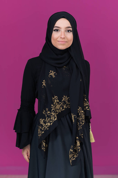 beautiful muslim woman in fashinable dress with hijab isolated on modern pink background representing concept of modern islam and ramadan kareem. High quality photo - Foto, Bild