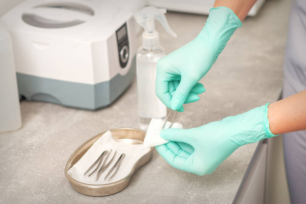 La mano desinfecta pinzas con sistemas de limpieza para instrumentos médicos. Limpiador ultrasónico - Foto, Imagen