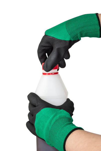 ゴム製の作業用手袋の手は自動車油のキャニスターを保持しています。白い背景に隔離された. - 写真・画像
