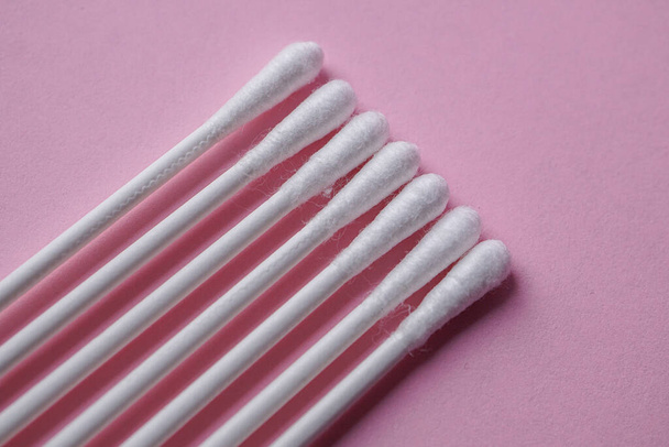 tamponi di cotone su fondo rosa, prodotto cosmetico e igienico  - Foto, immagini