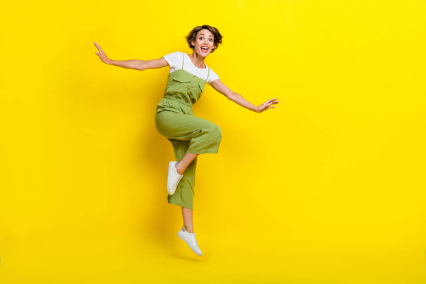 Full length photo of attractive girl youngster summertime vacation jumping celebrate black friday season carefree isolated on yellow color background. - Fotoğraf, Görsel