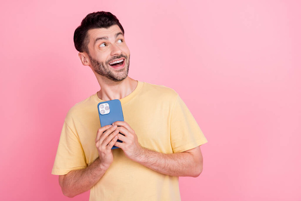Photo of surprised man wear yellow trendy clothes interested look empty space impressed low price devices isolated on pink color background. - Fotoğraf, Görsel