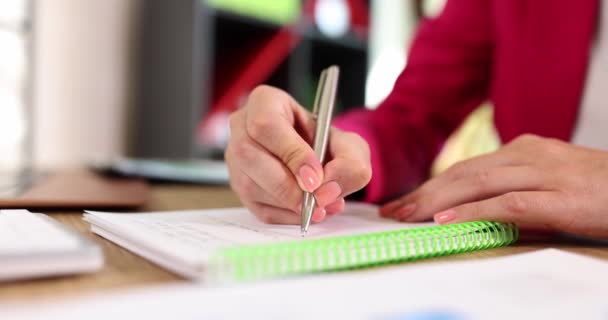 Mujer mano escribe nota con bloc de notas de cerca con bolígrafo. Concepto de educación empresarial y lista de tareas - Imágenes, Vídeo