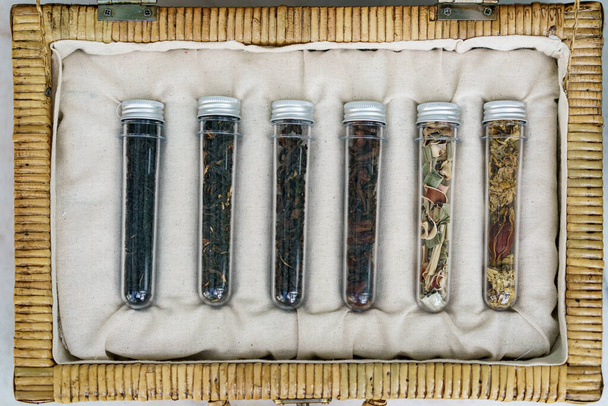 Έξι σωληνάρια από διαφορετικές συλλογή φύλλων τσαγιού σε ψάθινο καλάθι - Φωτογραφία, εικόνα