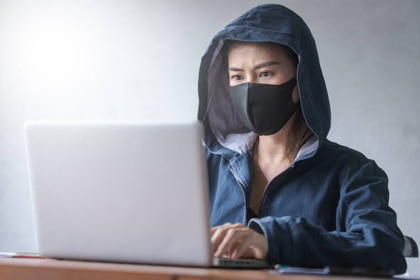 hacker profesional mujeres jóvenes con una bata azul con una capucha - Foto, Imagen