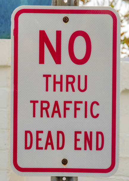 Függőleges Nincs forgalom zsákutcában jel La Jolla, Kalifornia. Fényvisszaverő felirat piros betűkkel és peremekkel a fehér betonfalak és a nagy kék váza mellett. - Fotó, kép