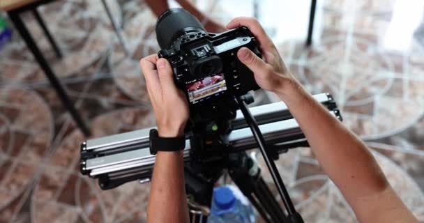 Videógrafo profesional con cámara en trípode graba formación empresarial. Blogger escribe un curso alentador para el blog - Metraje, vídeo