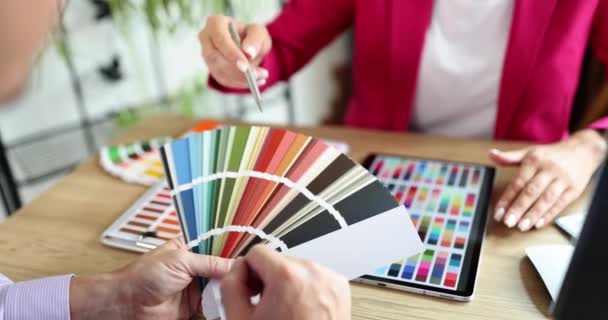 Detailní záběr rukou architekta a zákazníka při výběru vzorků barev na stěny. Návrhář interiérů se dívá na barevné hodinky pro projekt - Záběry, video