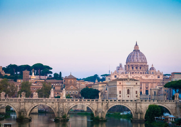 ローマ,イタリア- 2020年6月:サン・ピエトロ大聖堂ドーム(バチカン市国)を背景にしたティバー川の橋の夕日のパノラマ-ローマ,イタリア - 写真・画像