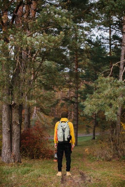 Turista en un sendero en el bosque con una mochila y una lámpara. - Foto, imagen