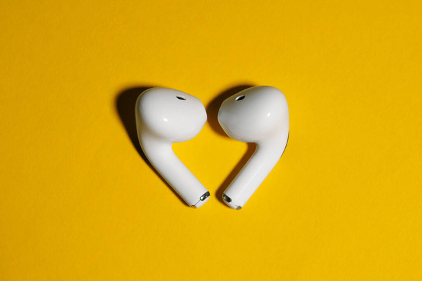 ασύρματα ακουστικά σε κίτρινο φόντο mockup top view close-up - Φωτογραφία, εικόνα