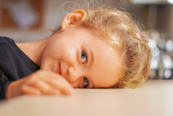 Beautiful kid captured in a portrait smiling and lying down - 写真・画像