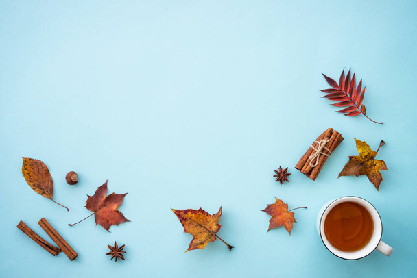 Autumn flat lay background on blue. Hot tea, fall leaves and spices. Flat lay with copy space. - Valokuva, kuva