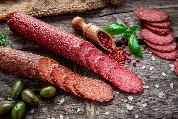 Best quality italian salami on old wooden table. Salami. Dried organic salami sausage or spanish chorizo - Valokuva, kuva