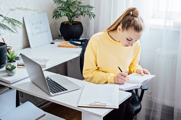 Flexibilní práce, flexibilní práce. Mladá žena na volné noze pracuje v domácí kanceláři s notebookem a dokumenty. Pružný pracovní plán - Fotografie, Obrázek