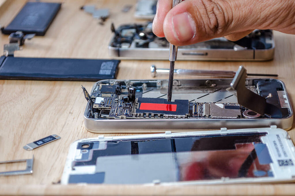 "Reparaciones de la placa base del teléfono en la placa base para el teléfono inteligente por el técnico profesional en el escritorio." - Foto, imagen