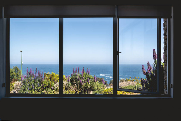 Big window with beautiful view of seascape, grass and lavender flowers in a sunny day - Foto, immagini