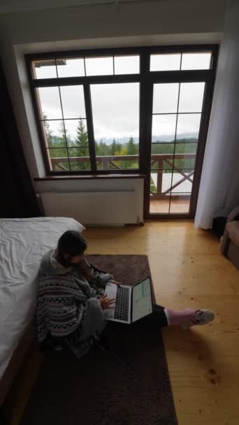Elfoglalt fiatal nő laptoppal ül a padlón dupla ágy és hálózatépítés, vagy csak eltöltött szabadidő a különböző weboldalakon - Felvétel, videó