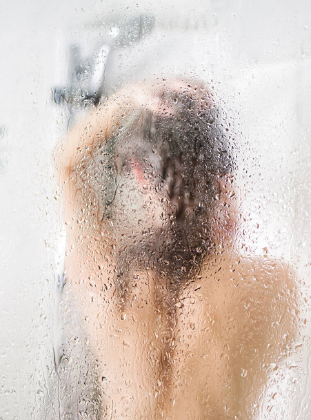 Mujer lavando la cabeza detrás de vidrio - Foto, imagen