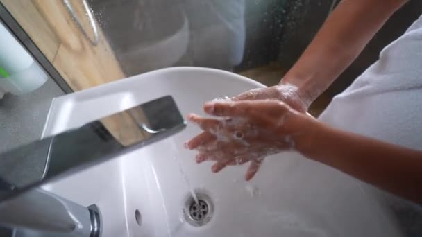 close up woman washing hands with soap and water, white foam, in the bathroom, under tap in the sink, personal hygiene and care, coronavirus prevention - Felvétel, videó