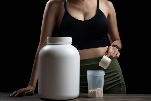 Close up of woman with measuring scoop of whey protein - Photo, Image