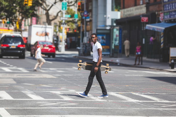 Black Boy Walking in the City Holding Longboard - Foto, Imagem