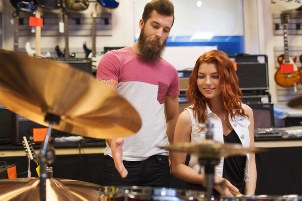 man and woman with drum kit at music store - Valokuva, kuva