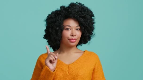 Egy afro-amerikai nő nem mutathat semmit. Komoly női arckifejezés. Nem értett egyet Afro haj 20-as évek fekete hölgy integető ujj mutatja negatív válasz izolált kék stúdió háttér lassított 4K - Felvétel, videó