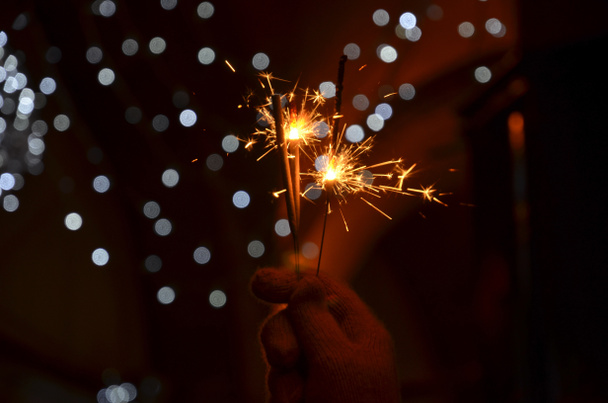 Fête du Nouvel An avec feux d'artifice brillants tenus à la main
 - Photo, image