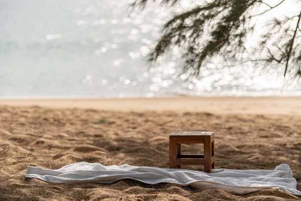 Ξύλινη καρέκλα και λευκή πετσέτα στην παραλία, φόντο στον ωκεανό - Φωτογραφία, εικόνα